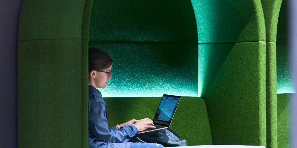 A person sitting in an alcove working on a computer
