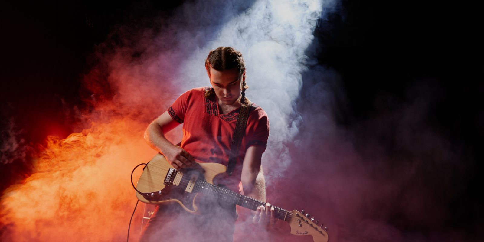 A person standing up, playing an electric guitar