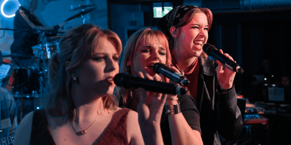 Three female students singing