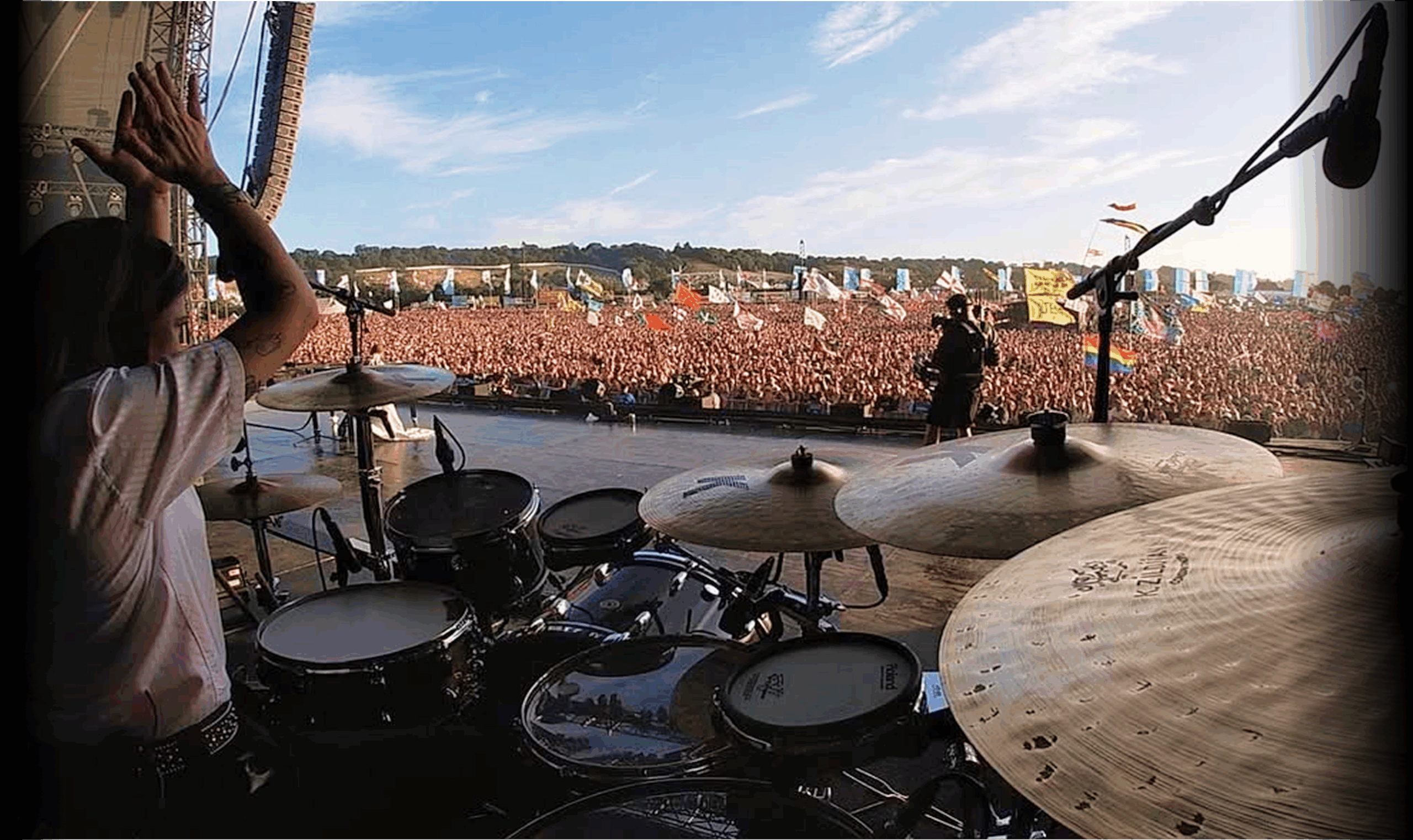 Drummer on stage in front of a festival crowd