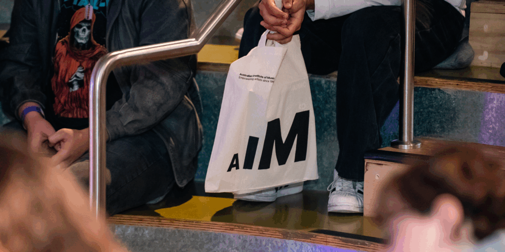 A student holding a tote bag with AIM logo.