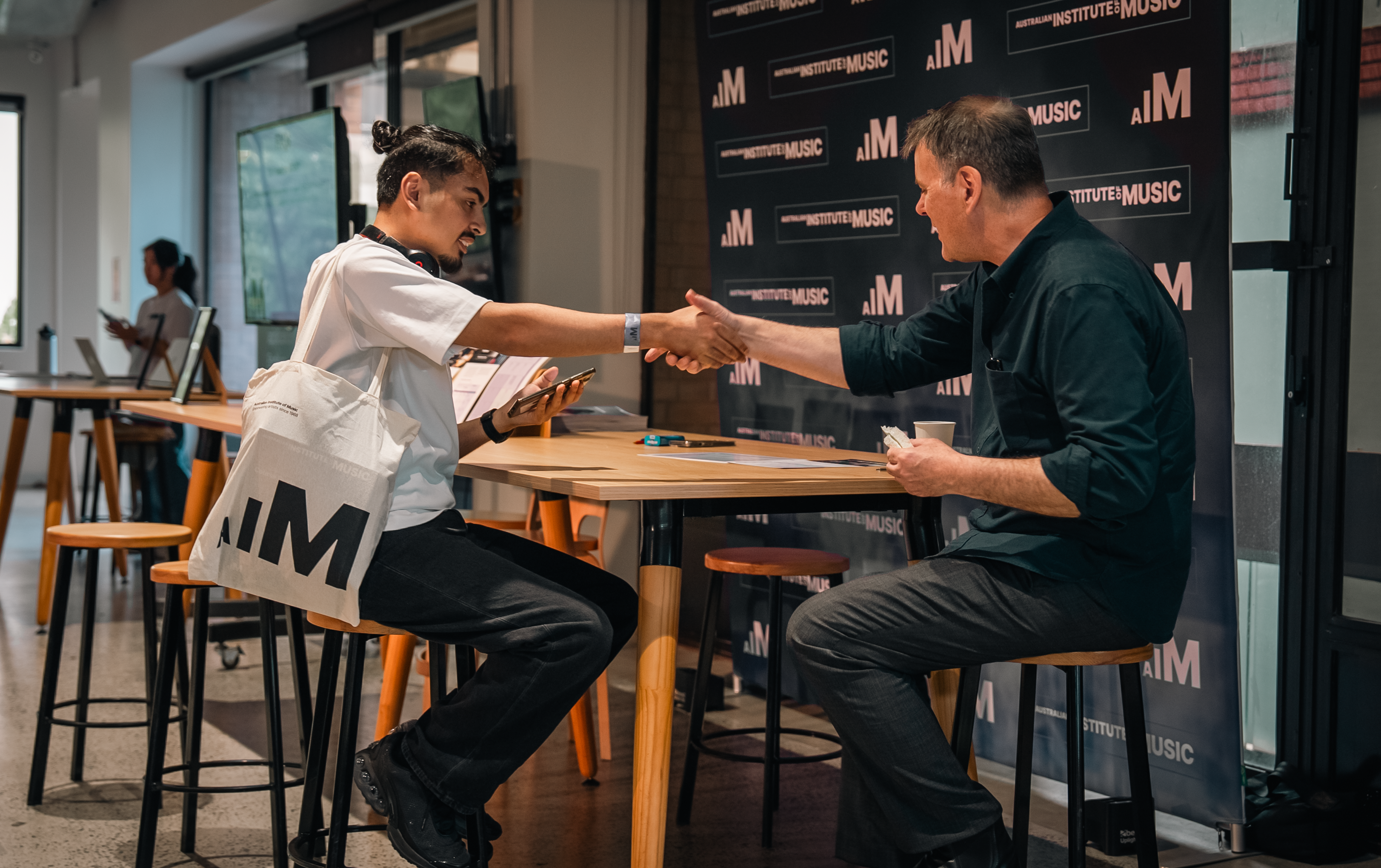 A male student and male teacher shaking hands. 