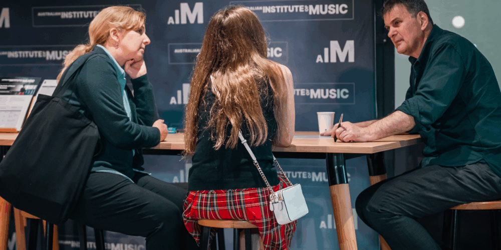 Three people sitting around a table.